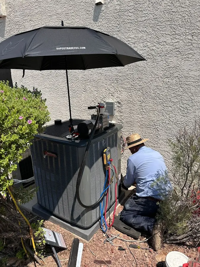 HVAC technician performing outdoor AC maintenance in Dartmouth